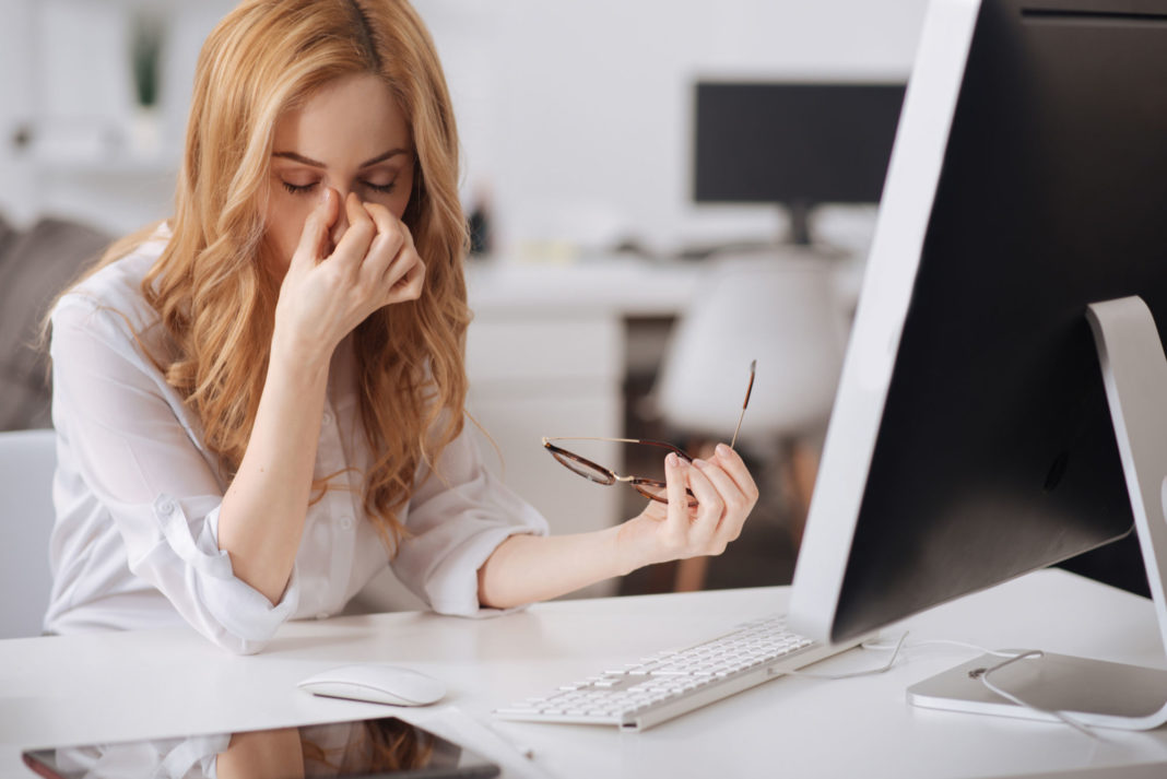 Tired young secretary working in the office